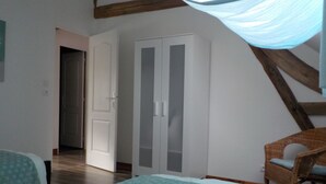 A bedroom with two beds, a wardrobe, and a chair. - IDEAL FAMILY HOUSE (Bracieux)
