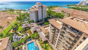 Ein Resort mit großem Pool, mehreren Gebäuden und Blick aufs Meer.