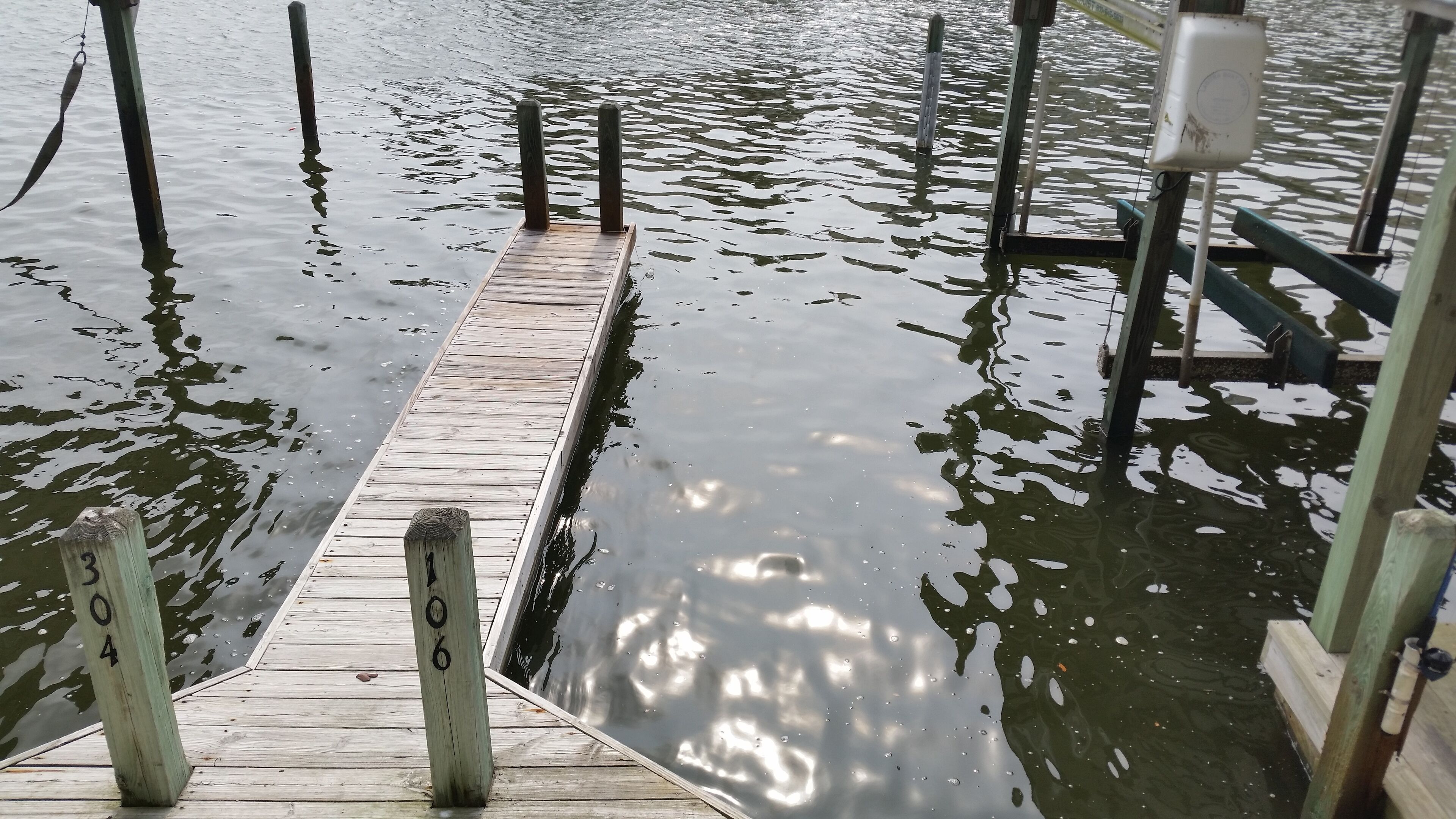 A wooden dock extending into a body of water with numbered posts.