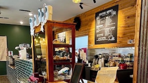 A coffee shop interior with a wooden counter, seating area, and a menu board.