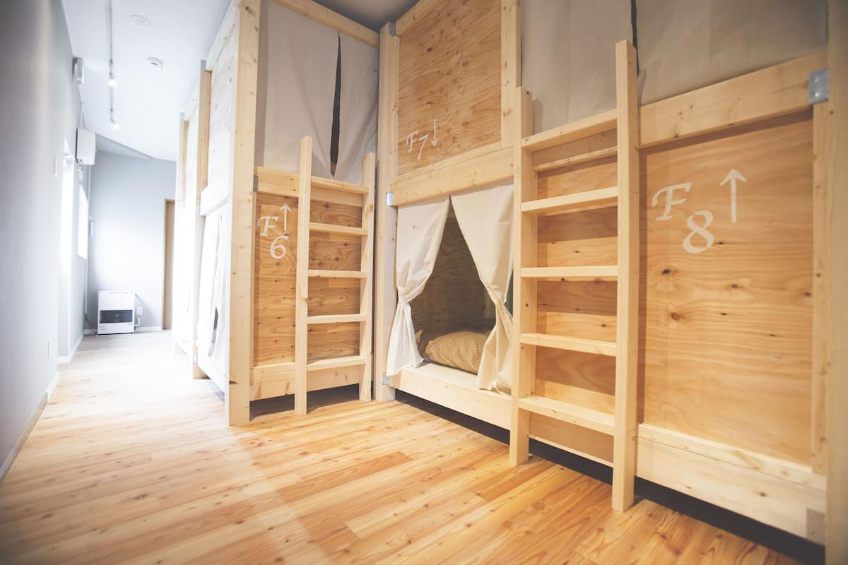 Una habitación con literas, paredes de madera y suelo de madera.