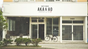 A building with a sign reading "GUEST HOUSE AKA & AO" and a number "0464" on the door. - Noboribetsu Guest House AKA & AO - Hostel (Noboribetsu)
