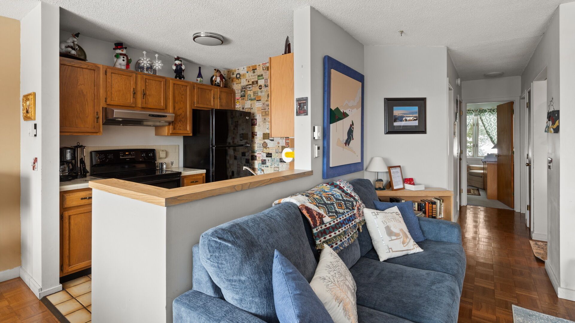 A modern kitchen with wooden cabinets, a black refrigerator, and a built-in stove.