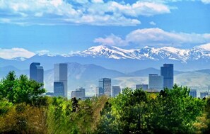 A cityscape with modern skyscrapers and a mountain range in the background. - . Best in Denver (Denver)