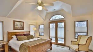 A bedroom with a wooden bed, a chair, a ceiling fan, and large windows. - . Best in Denver (Denver)