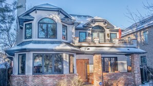 A two-story house with a large bay window, a covered porch, and a brick exterior. - . Best in Denver (Denver)