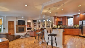 A spacious living area with a fireplace, a television, and a kitchen with wooden cabinets and a stainless steel refrigerator. - . Best in Denver (Denver)