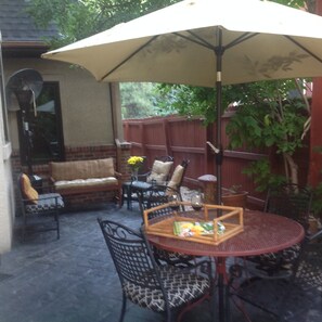 An outdoor patio with a round table, chairs, and a large umbrella. - . Best in Denver (Denver)