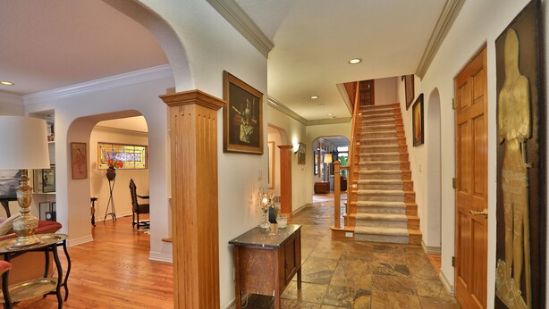 A spacious hallway with a wooden staircase, stone flooring, and wooden doors. - . Best in Denver (Denver)