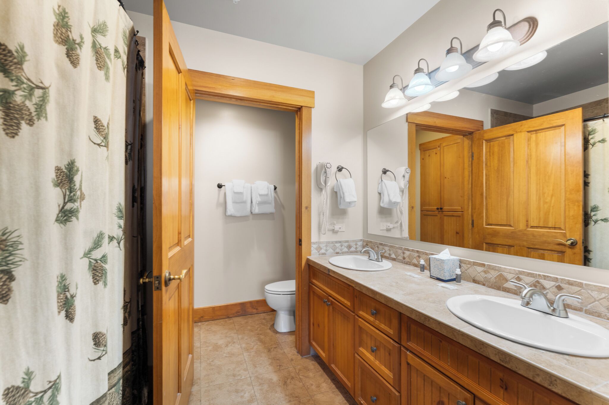 Une salle de bain avec des meubles en bois, un lavabo et des toilettes.