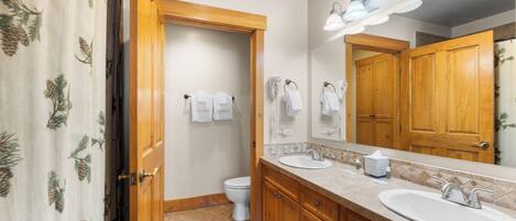 Une salle de bain avec des meubles en bois, un lavabo et des toilettes.