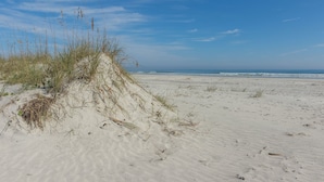A sandy beach with sparse vegetation and a clear blue sky. - Oceanfront - 3 Bedroom Renovated 1,800 sq ft. + Huge Balcony -  Casual Elegance (St. Augustine Beach)