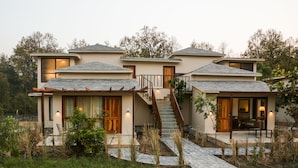 A modern two-story house with a stone pathway leading to the entrance, surrounded by greenery. - Saraca Resort & Spa Corbett (Salt)