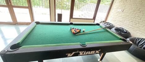 A pool table with a green felt surface, branded with 'Vinex'.
