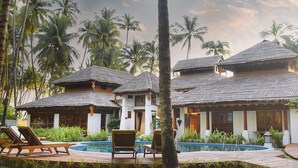 A resort with multiple thatched-roof buildings, a swimming pool, and lush greenery. - Yoma Cherry Lodge (Ngapali)