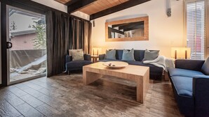 A modern living room with a wooden coffee table, two sofas, and a large mirror on the wall. - Walk to Village Gondola. Updated 4BR 3 Bath for 2 families. Sleep 10. Fireplace. (Mammoth Lakes)