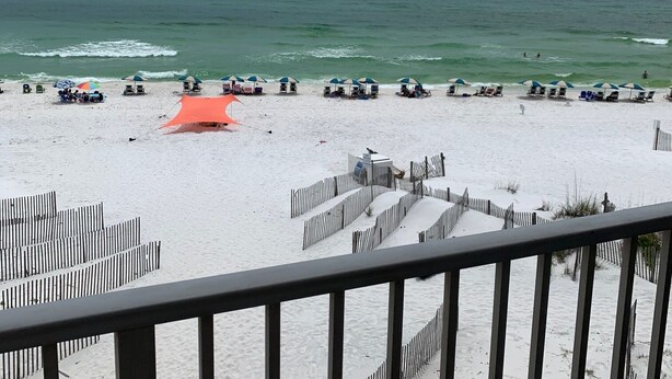 A beach with umbrellas and lounge chairs, a wooden fence, and a view of the ocean. - Remodeled 2020  Gulf front Private condo (Santa Rosa Beach)