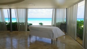Ein Zimmer mit einem Bett, großen Fenstern und Blick aufs Meer.