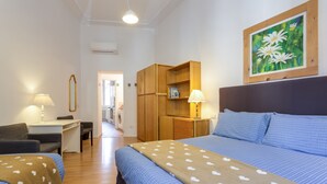 Une chambre à coucher avec un lit, un bureau, une chaise, une armoire et un tableau accroché au mur.