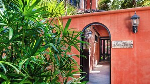 Un sentiero stretto che conduce all'ingresso di un edificio con un cartello che recita 'Alma Serena'.