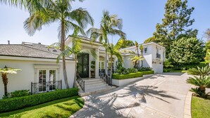 A two-story house with a front entrance, a driveway, and a well-maintained lawn.