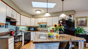 A modern kitchen with a central island, built-in appliances, and a large window above the island. - Bella Regalo, Private 2BR, 2BA Mountain Escape, Upgraded with Panoramic Views (Pisgah Forest)