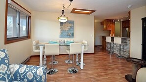 A modern kitchen with a dining area, wooden flooring, and a bar area with stools. - Amazing Mountain & Lakefront Views- Special!  1 FREE nite w/ 7 nite booking (Dillon)