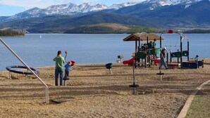 A playground with swings and slides, a small shelter, and a sign with red text. - Amazing Mountain & Lakefront Views- Special!  1 FREE nite w/ 7 nite booking (Dillon)