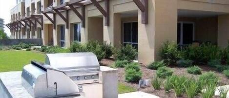 A building with a barbecue area and a well-maintained garden.