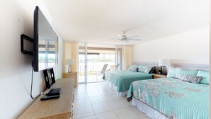 A hotel room with two beds, a TV, a desk, and a balcony with a chair. - Top Floor, Corner 2 Bedroom, Ocean View, Beach Cabana, 3 pools, Jacuzzi. (Kaanapali)