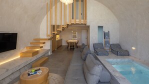 A modern interior with a pool, a staircase, a sofa, and a dining area. - Santorini Soul Villas (Santorini)