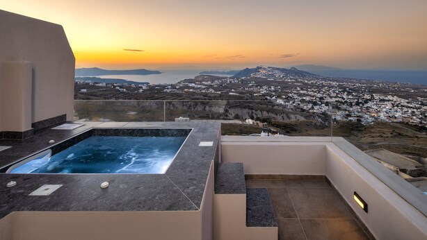 A rooftop pool with a view of a coastal town at sunset. - Santorini Soul Villas (Santorini)