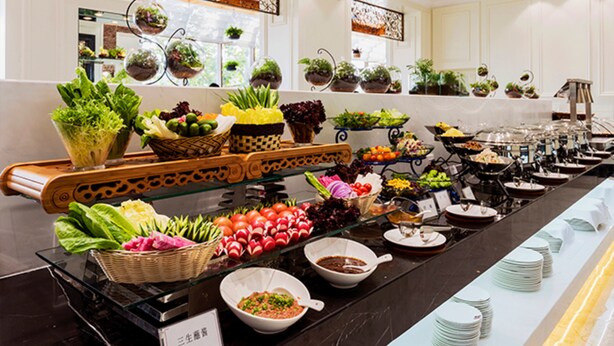 A buffet with various food items and a selection of potted plants on shelves. - Dalian Bangchui Island Hotel (Dalian)