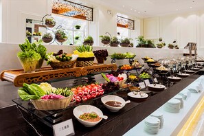 Un buffet proposant une variété de plats et une sélection de plantes en pot disposées sur des étagères.