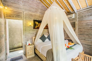 Un dormitorio con cama con dosel, paredes de madera, una mesita de noche pequeña y un cuadro en la pared.