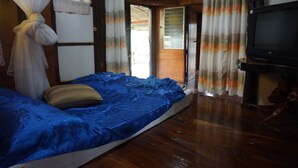 A room with a bed, a television, and a door leading outside.