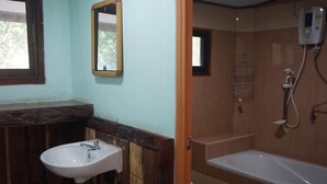 A bathroom with a sink, mirror, and bathtub.