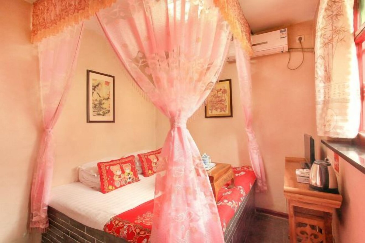 A room with a bed, a bedside table, and a wall-mounted air conditioner.