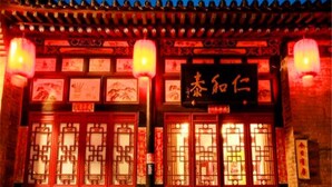 Ein traditionelles chinesisches Gebäude mit aufwendigen roten Türen und Laternen.