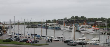 En småbåtshamn med förtöjda båtar, en gångväg och en byggnad i bakgrunden.