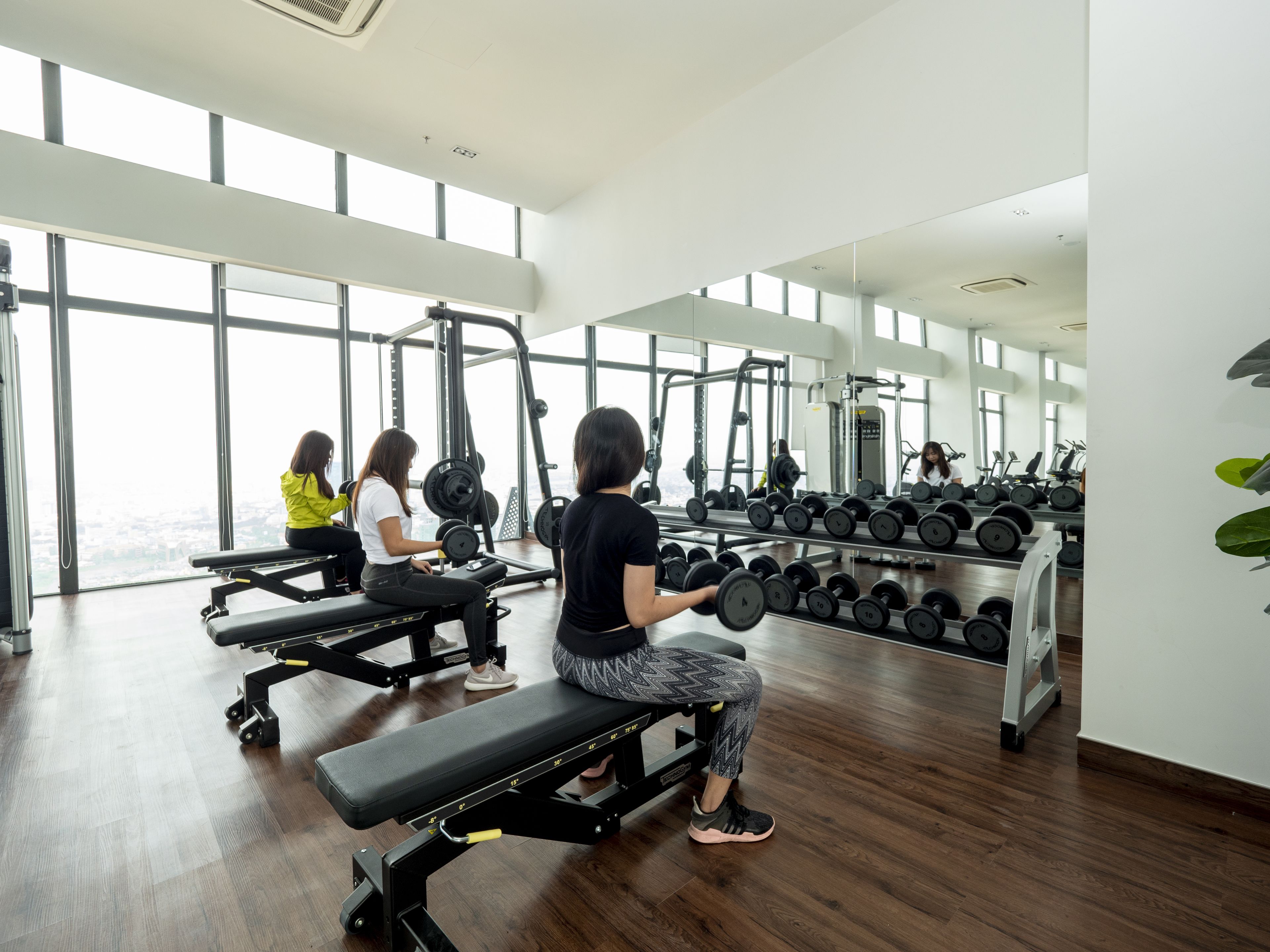 Una palestra con panche, rastrelli per pesi e attrezzature per esercizi.