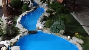 A small, winding pool with a blue center, surrounded by rocks and plants. - Ostello Villafranca (Pignola)