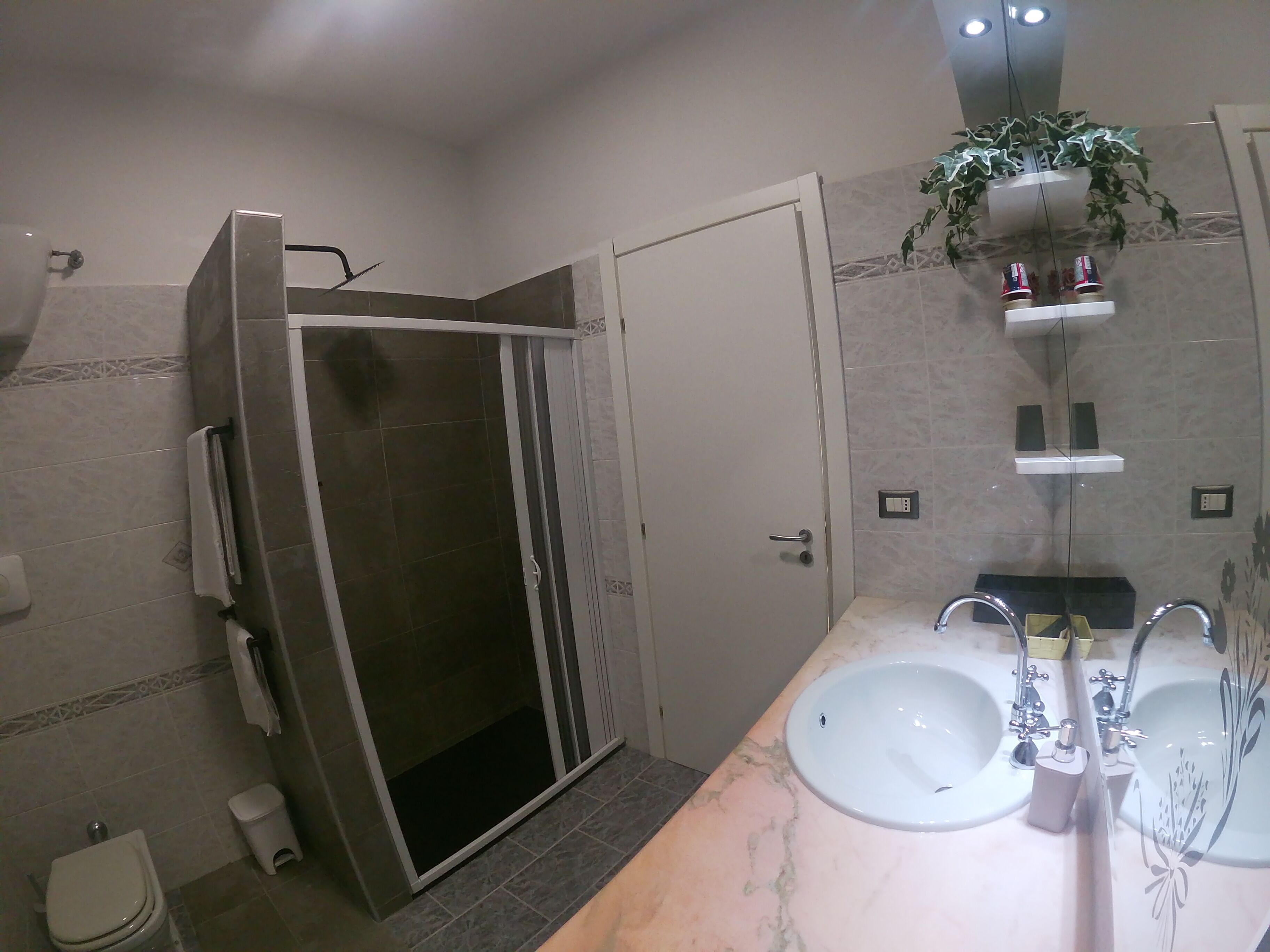 A bathroom with a shower, toilet, and two sinks.
