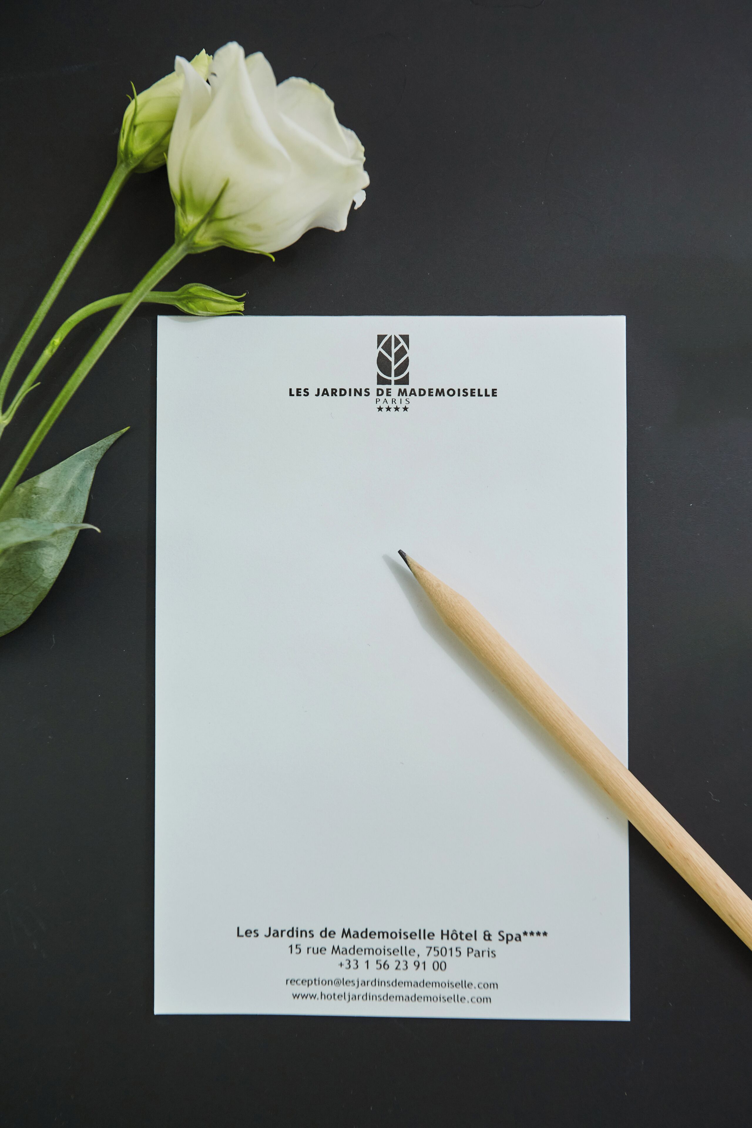 Tarjeta de presentación del Hotel & Spa Les Jardins de Madame Moiselle, con la dirección y la información de contacto.