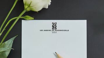 Tarjeta de presentación del Hotel & Spa Les Jardins de Madame Moiselle, con la dirección y la información de contacto.
