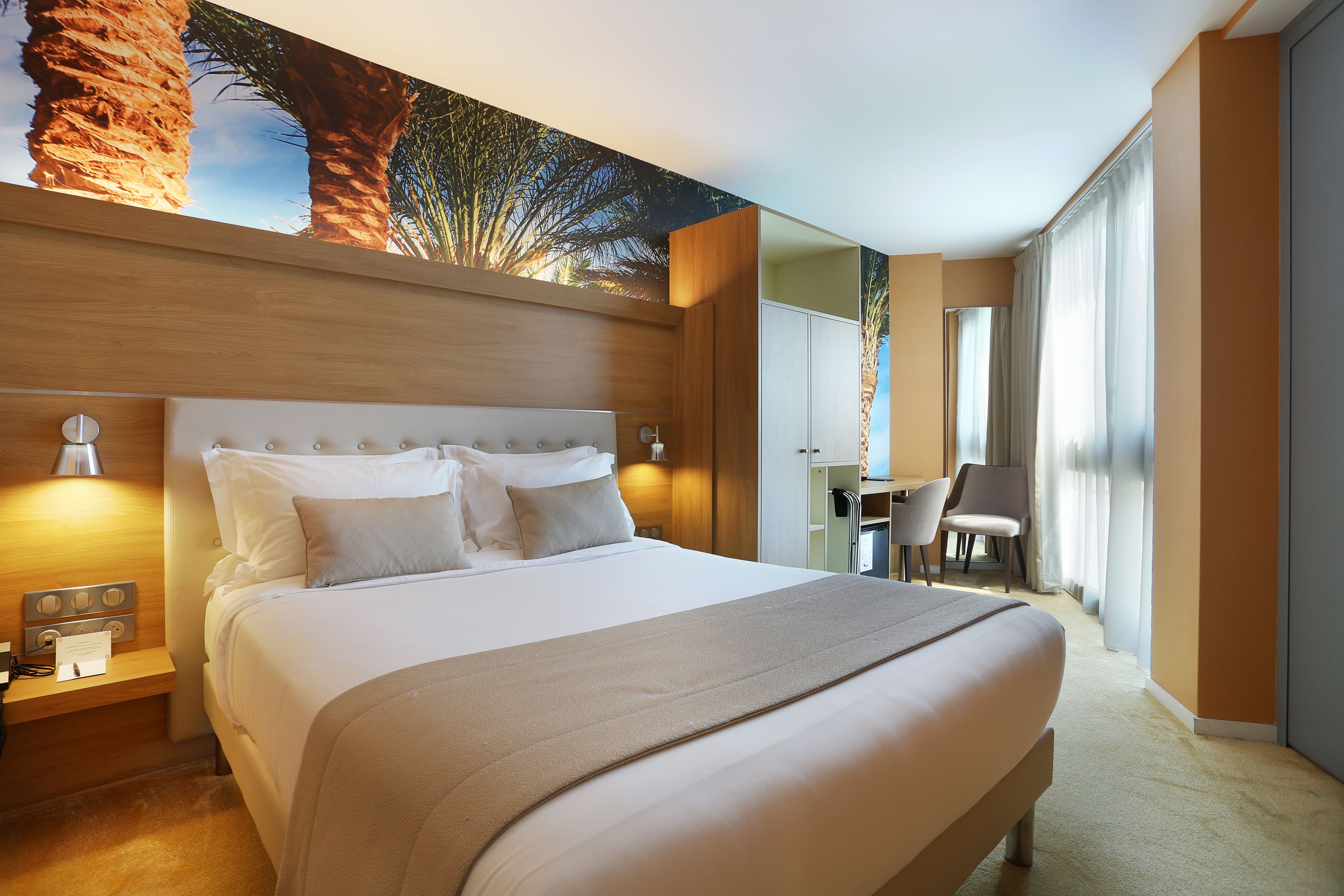 Una habitación de hotel con una cama grande, un escritorio y una silla.