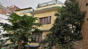 A two-story building with a sign reading "NEPALI HIVE Apartments." - The Nepali Hive (Kathmandu)