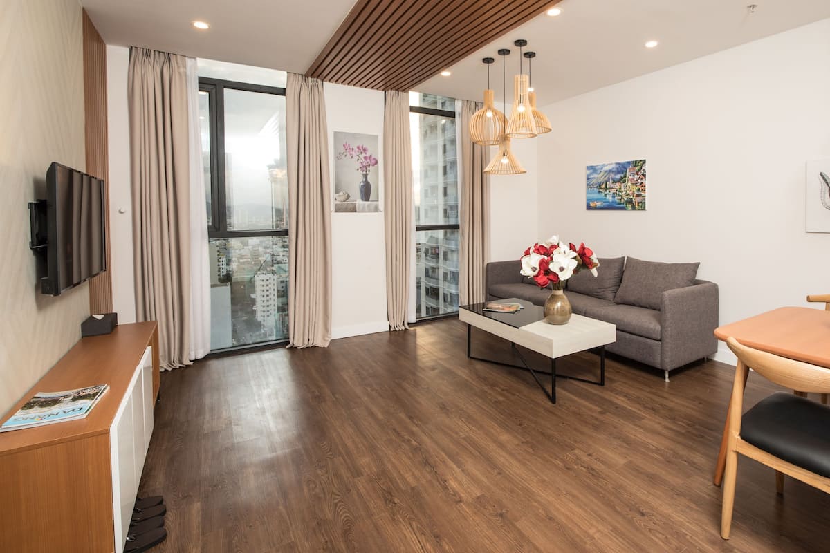 A modern living room with a sofa, coffee table, and dining table.