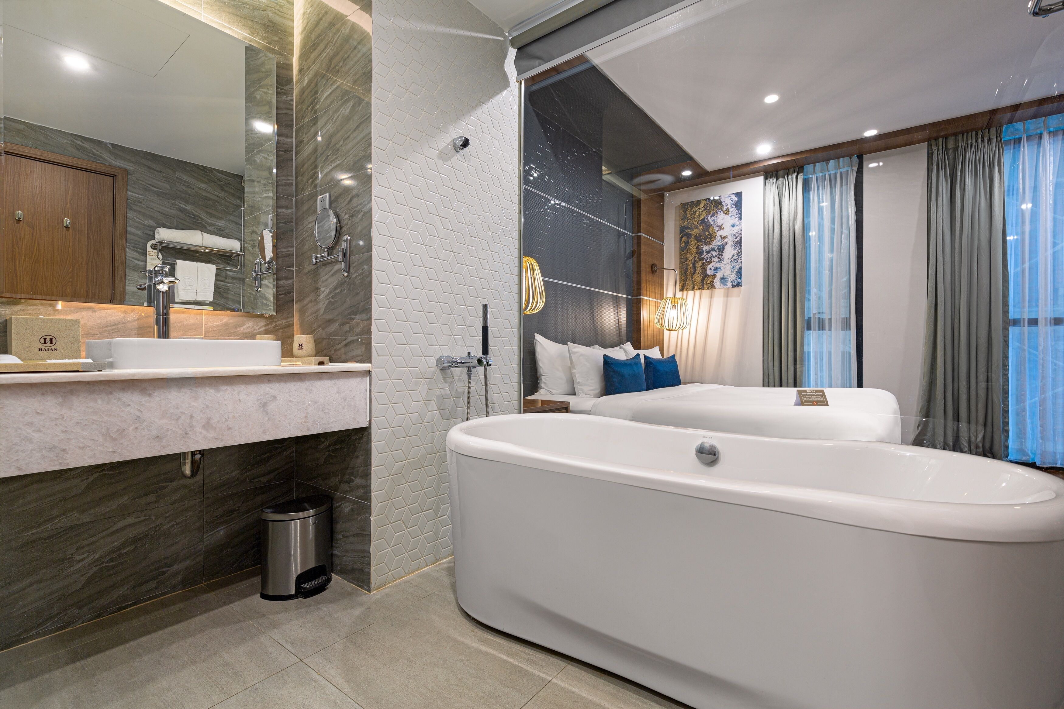 Un baño moderno con una bañera grande, un tocador con espejo y una zona de ducha.