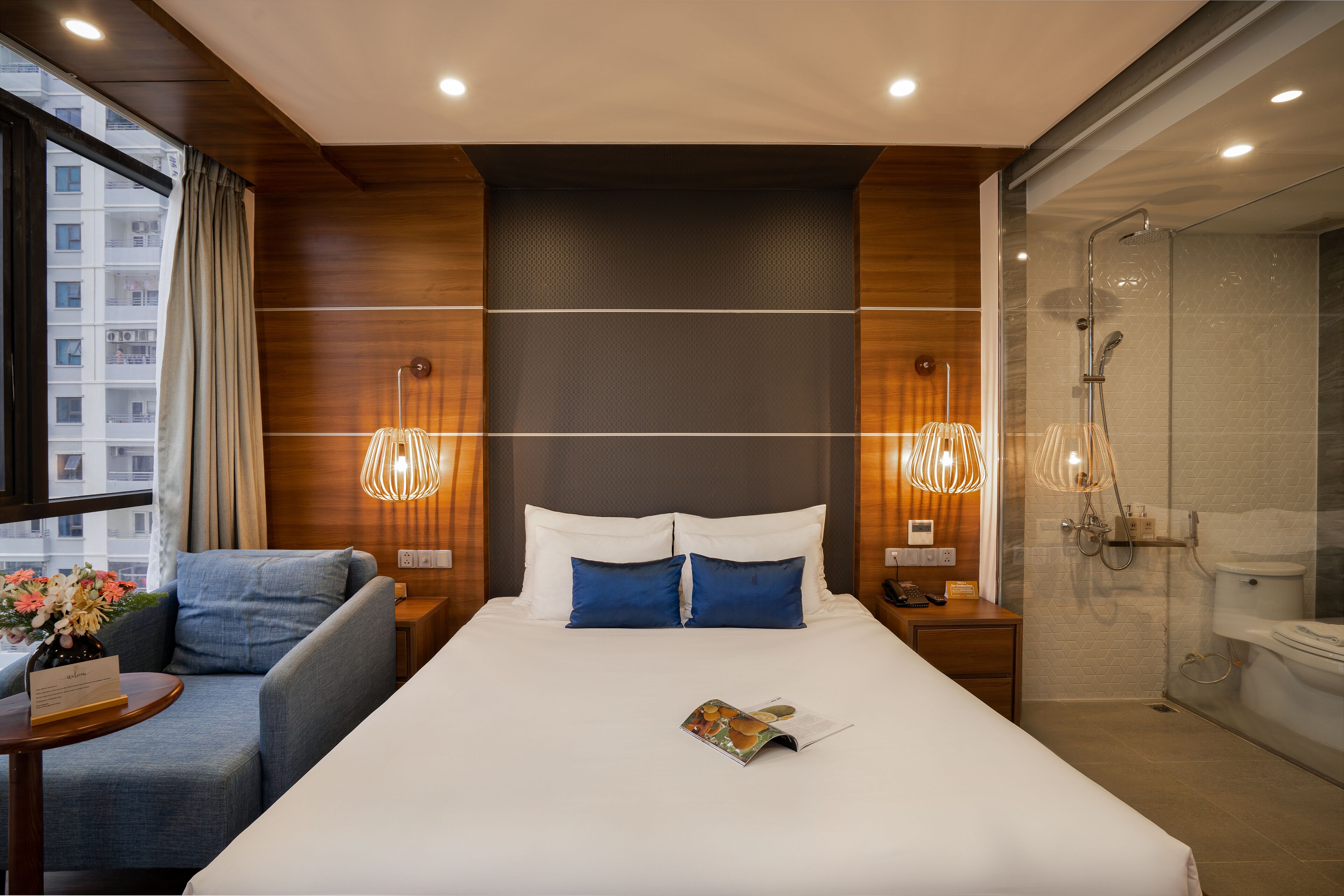 Une chambre d’hôtel moderne dotée d’un grand lit, d’un coin salon, d’une douche et offrant une vue sur la ville.